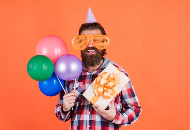 Prepare-se para o gerente de eventos de aniversário com caixa de presente macho brutal na festa homem engraçado no chapéu de aniversário feliz festa de celebração do feriado frequentador enlouquecendo se divertindo com balões