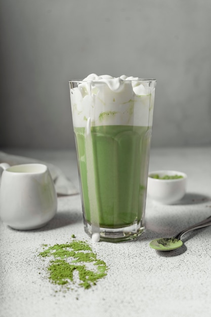 Foto preparou chá matcha em um copo transparente. uma deliciosa bebida feita de pó de chá verde japonês. posição vertical