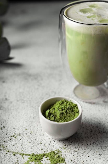 Preparou chá matcha em um copo transparente. uma deliciosa bebida feita de pó de chá verde japonês. posição vertical