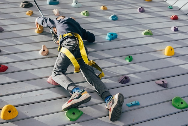 Foto preschololer boy escalada muro de entrenamiento ocio infantil estilo de vida al aire libre concepto deportivo