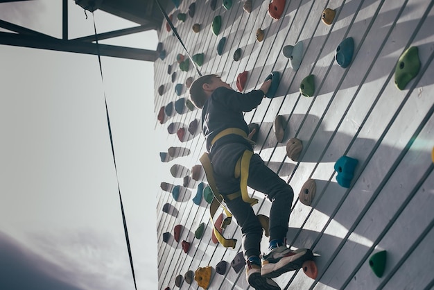 Foto preschololer boy escalada muro de entrenamiento ocio infantil estilo de vida al aire libre concepto deportivo
