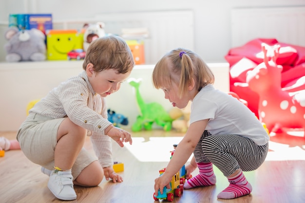 Preschoolers jogando juntos na sala de jogos