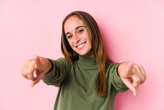 Foto presentación caucásica joven de la mujer que sonríe alegre aislada que señala al frente.