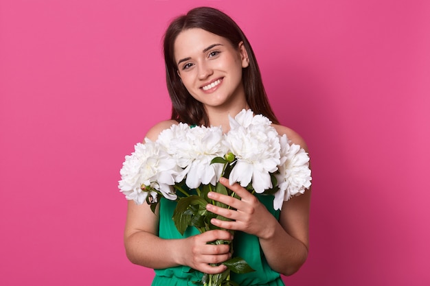 Presentación femenina linda sonriente aislada sobre rosa