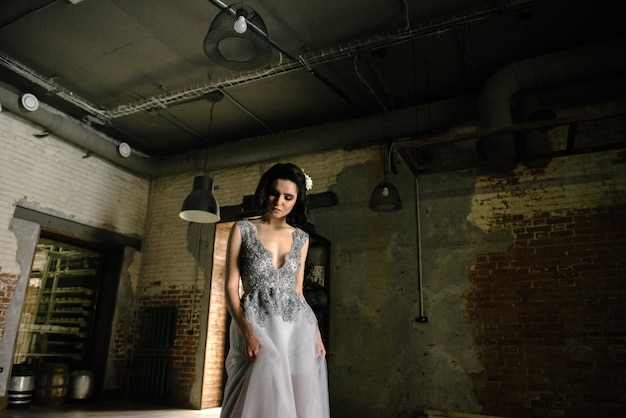 Presentación modelo en un vestido de boda largo blanco dentro por la ventana.