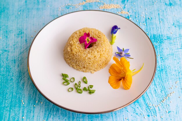 Presentación de plato de quinua decorado con flores comestibles