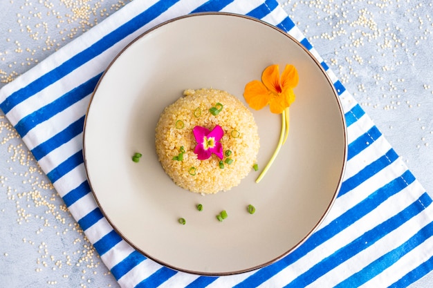 Presentación de plato de quinua decorado con flores comestibles