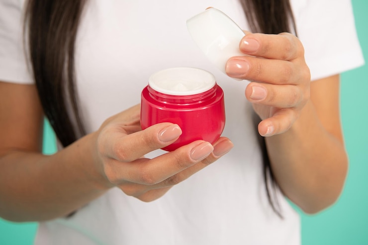 Foto presentación de producto cosmético para la piel. crema de manos abierta. manicura de manos. mujer aplicando crema para la piel. hábito diario y cuidado personal. belleza del cuidado de la piel. cosmética de belleza. vista recortada.