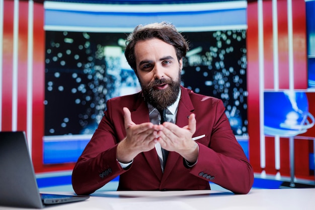 Presentador de programas de entrevistas que aborda eventos diarios en un estudio de noticias y brinda información en vivo sobre los últimos acontecimientos en todo el mundo. Presentador masculino creando reportajes en un canal de televisión internacional.