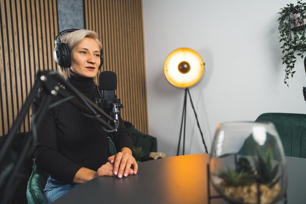 Presentadora de radio hablando en un podcast en vivo trabajando en un estudio