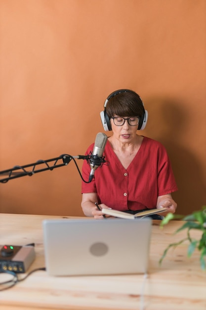 Presentadora de radio de mediana edad haciendo grabación de podcast para transmisión de programas en línea y concepto de dj