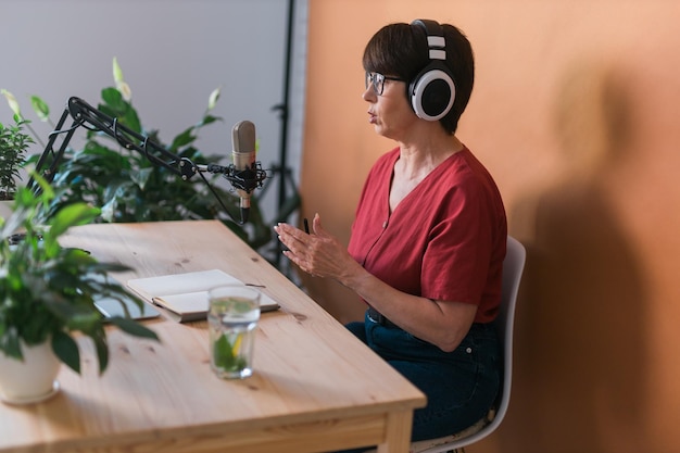 Presentadora de radio de mediana edad haciendo grabación de podcast para transmisión de programas en línea y concepto de dj