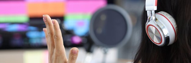 Presentadora de radio de mujer se sienta frente al monitor con auriculares concepto en vivo