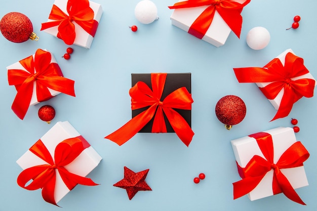 Presentar cajas sobre fondo azul tarjeta de felicitación vacaciones concepto regalo caja blanca atada con cinta roja