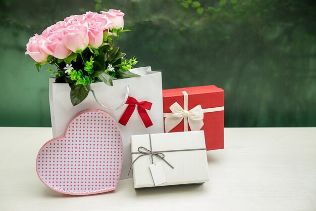 Foto presente la caja y la cinta de regalo en la tabla de madera blanca