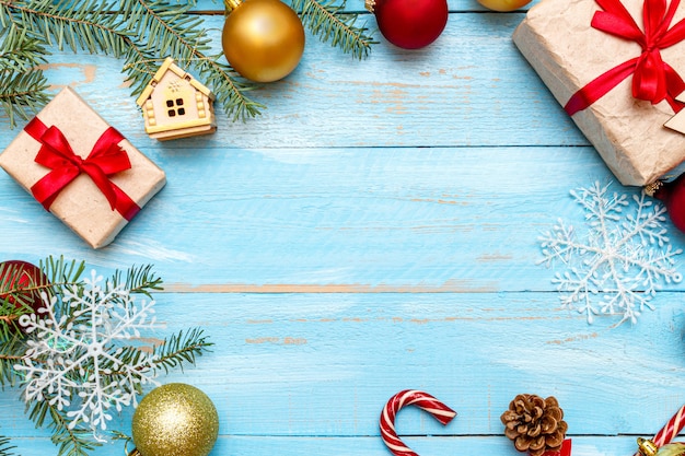 presente com laço vermelho e decoração de Natal no fundo de madeira pintado de azul