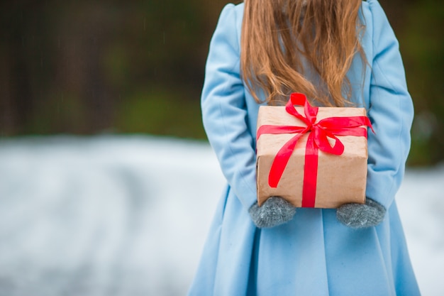 Presente de caixa de Natal closeup no garoto mãos no dia de inverno ao ar livre