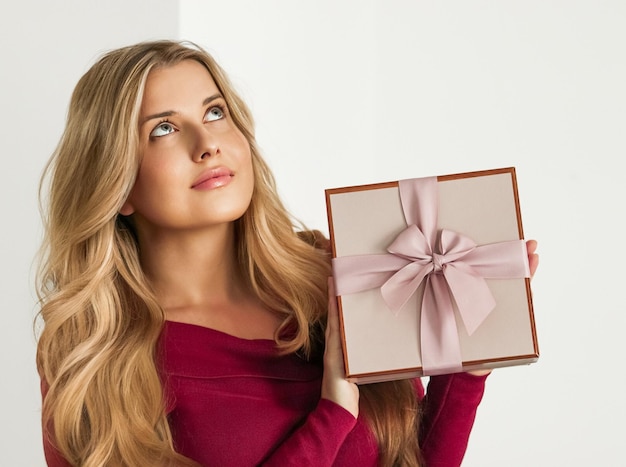 Presente de feriado para casamento de chá de bebê de aniversário ou entrega de assinatura de caixa de beleza de luxo mulher feliz segurando um presente rosa embrulhado