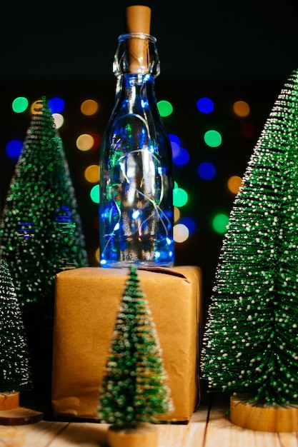 Presente de Natal ao lado de pequenas árvores de Natal