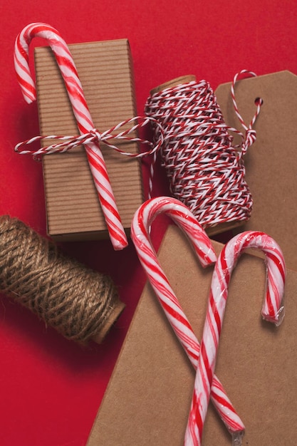 Presente de Natal festivo com bastão de doces em um fundo vermelho