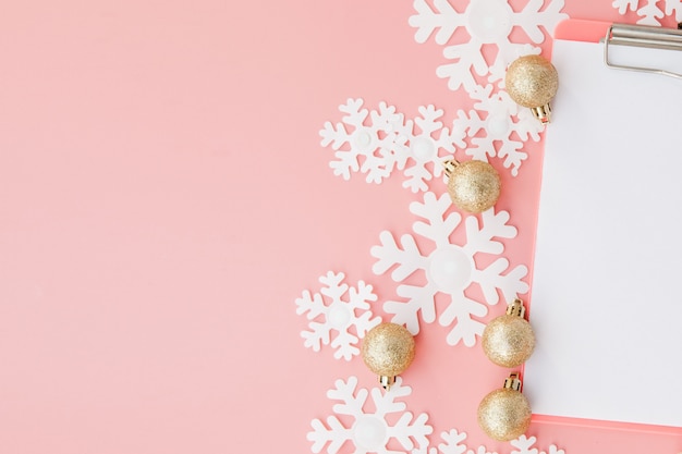 Presente de Natal nas mãos das mulheres e notebook em um fundo rosa, uma vista de cima