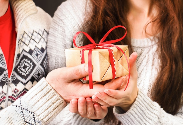 Presente de natal nas mãos de um jovem casal closeup