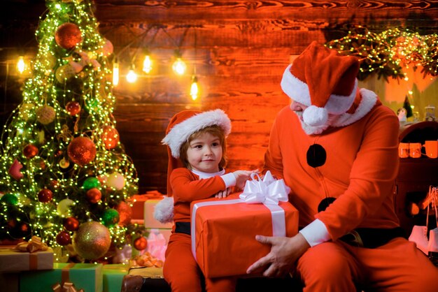 Presente de Natal, papai noel, papai noel e menino em casa, conceito de férias em família sorrindo.