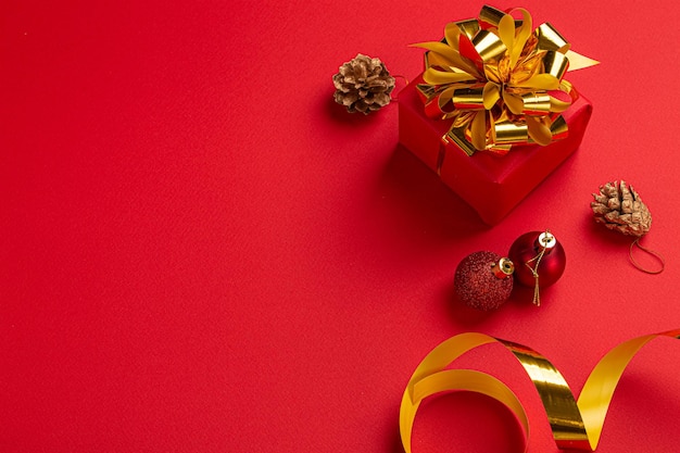 Presente de Natal vermelho com laço dourado e decoração redonda, vista superior