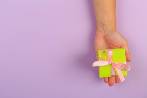 presente em mãos femininas em um fundo colorido vista superior Imagem