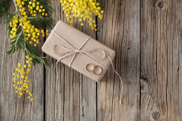 Presente embrulhado em papel ofício com flor de primavera amarelo