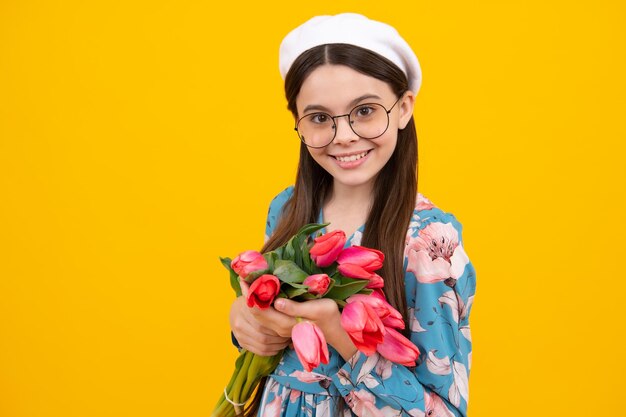 Presente floral criança feliz segurando tulipas menina com um buquê de tulipas felicita menina feliz surpreendida espaço de cópia celebração de aniversário e dia da mãe