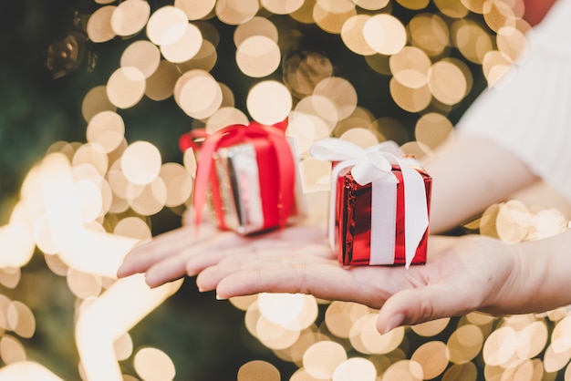 presente na mão com luz de fundo de bokeh de Natal