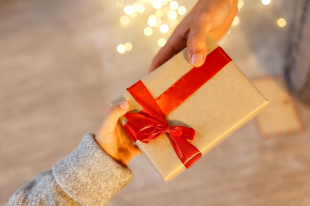 Presente nas mãos de uma criança. parabéns no dia de natal em casa