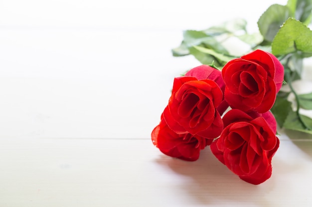 Presente presente com flor rosa vermelha na mesa de madeira
