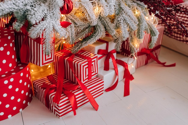 Presentes brilhantes com uma fita vermelha sob a árvore de Natal