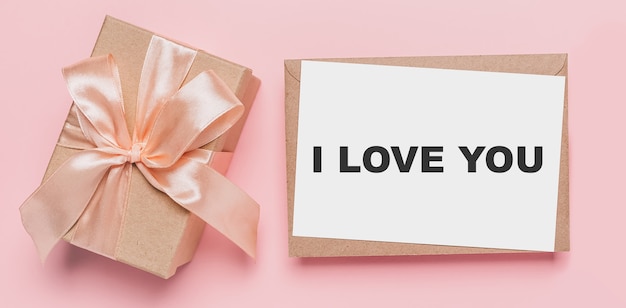 Presentes com carta de nota em fundo rosa isolado, conceito de amor e dia dos namorados com o texto eu te amo