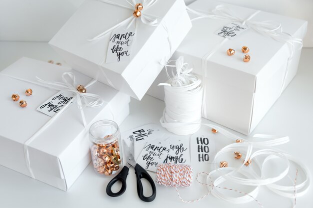Presentes de ano novo, caixas brancas sobre fundo claro com decoração de férias de inverno