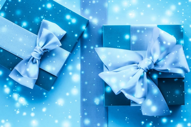 Presentes de férias de inverno e neve brilhante sobre fundo azul congelado Os presentes de Natal surpreendem