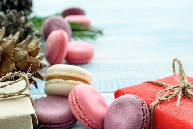 Presentes de macarons doces e cones de abeto e sobre fundo azul composição de ano novo de fundo de natal