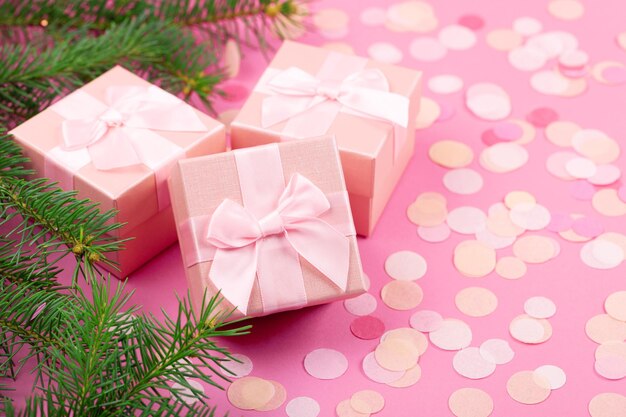 Presentes de natal com fita rosa em fundo pastel rosa com decorações festivas