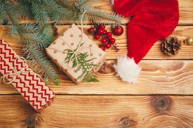 Presentes de natal com galhos de árvore do abeto em fundo de madeira