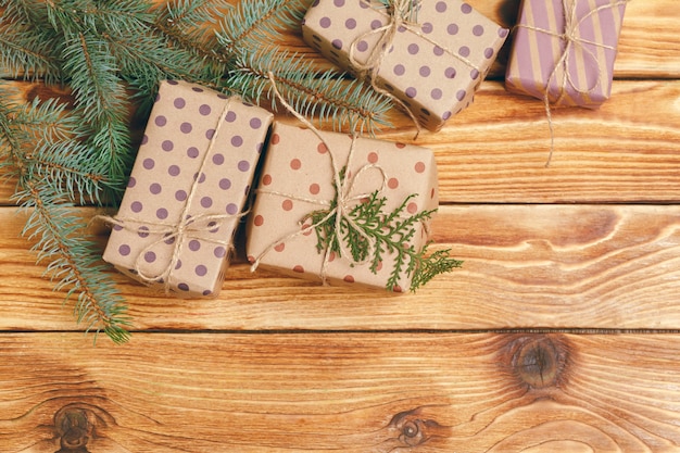 Presentes de Natal com galhos de árvore do abeto na superfície de madeira