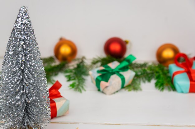 Presentes de Natal com um galho spruce e decorações em um fundo branco.