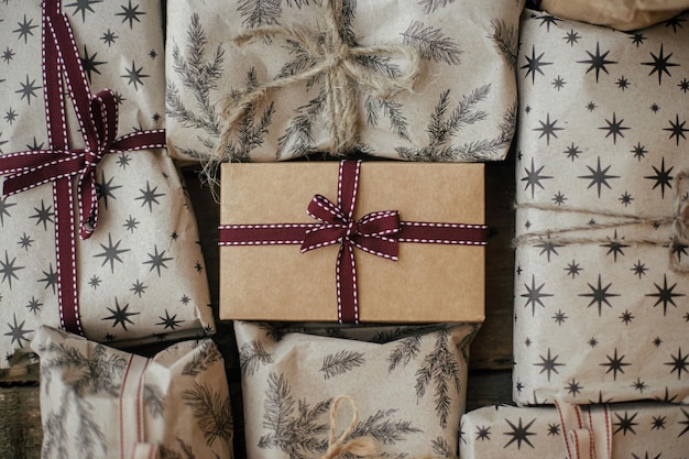 Presentes de natal elegantes com fitas na mesa de madeira rústica, plano, ecologicamente correto, feliz natal