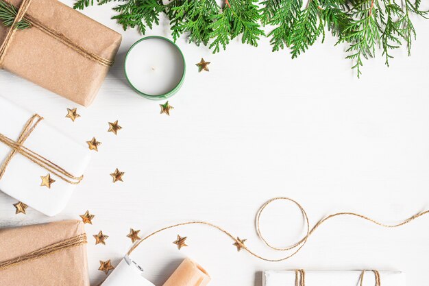 Presentes de Natal em materiais de papel artesanal para embalagem de galhos de pinheiro e estrelas cintilantes douradas