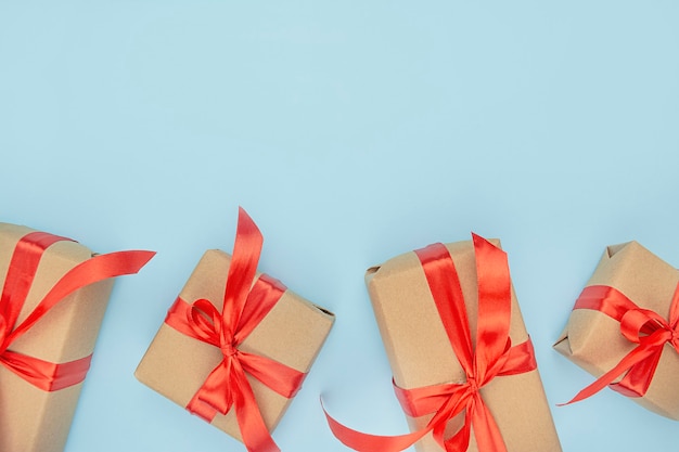 Presentes de natal em um fundo azul. caixas de presente de papel com laços vermelhos. bandeira. copie o espaço.