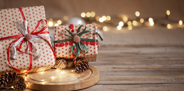 Presentes de Natal embalados em papel artesanal com fitas, guirlandas e cones decorativos no espaço da cópia do fundo desfocado.