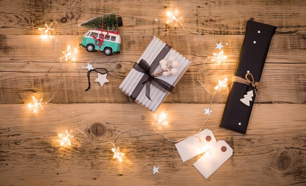 Presentes de natal embalados em papel preto e listrado e decorados com estrelas e guirlandas na mesa