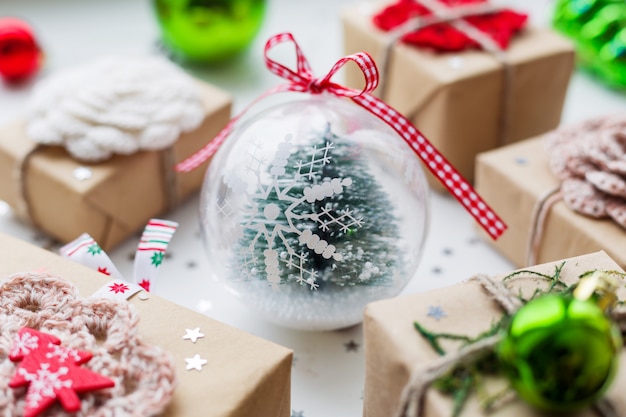 Foto presentes de natal, enfeites e abeto decorativo bola transparente dentro.