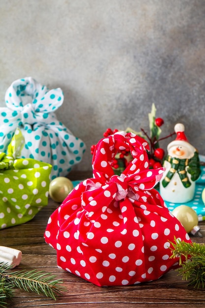 Presentes de natal furoshiki na mesa de madeira eco conceito de férias de natal copiar espaço